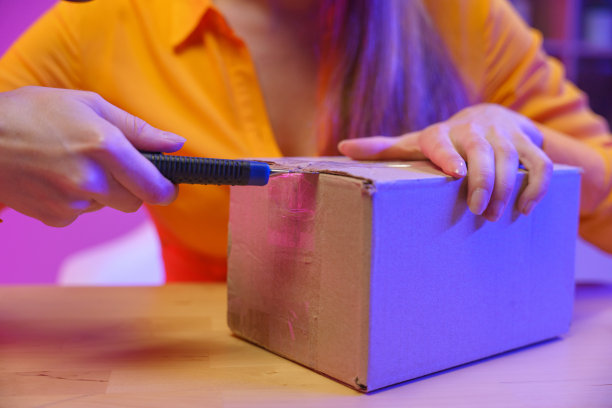 一个女人手里拿着一把固定的刀打开包裹的特写图片下载