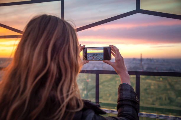 游客在巴黎夕阳下拍照图片下载