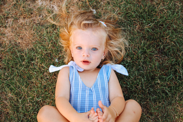 可爱的金发小孩躺在草地上图片下载