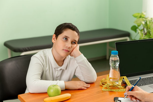 一个男孩在和营养学家约会。儿童肥胖问题。图片下载