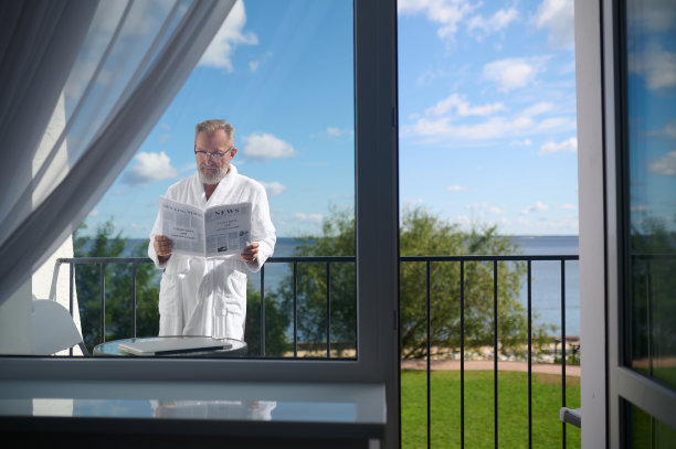 戴眼镜的绅士聚精会神地读着报纸上的新闻图片下载