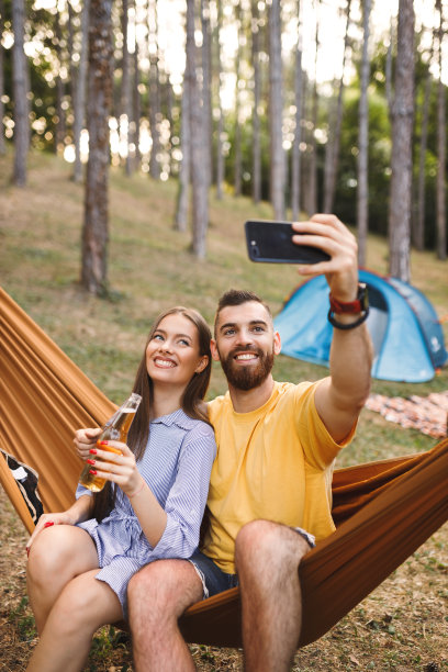 年轻夫妇一边在大自然中放松，一边视频通话图片下载