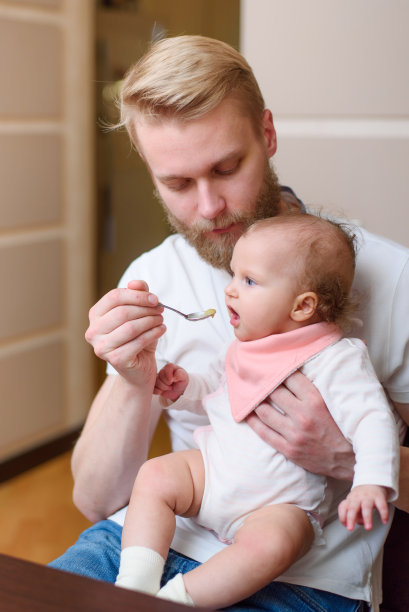 父亲在厨房里给女儿喂水果泥图片下载