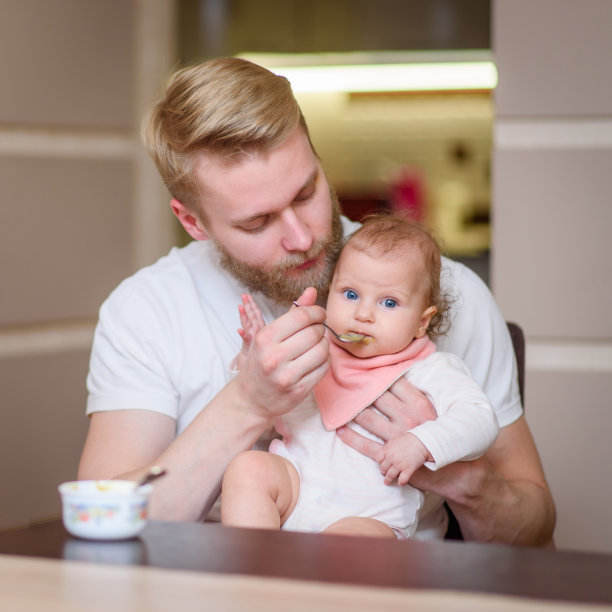 父亲在厨房里给女儿喂水果泥图片下载