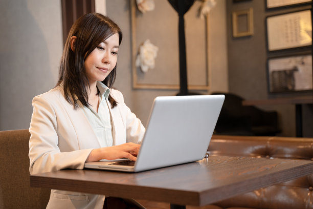 在餐馆用电脑进行远程工作的女人图片下载