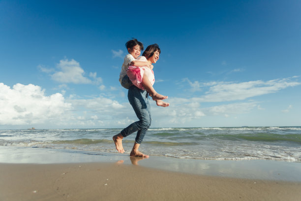 年轻快乐美丽的妈妈和她的女儿在海滩上玩得很开心。年轻的亚洲家庭度假有很多乐趣图片下载