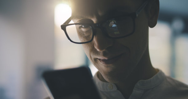 男人在用他的智能手机微笑图片下载