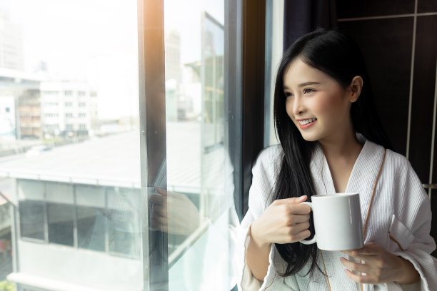 年轻漂亮的亚洲女子喝咖啡，享受美好的一天图片下载