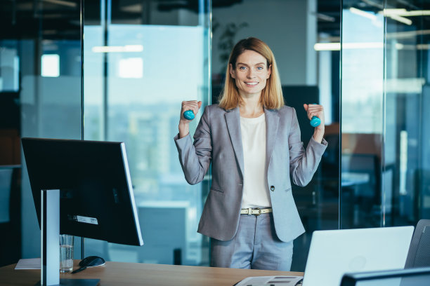 美丽快乐的女人在办公室工作时做运动，在休息时，商业女人监测健康从事健身图片下载