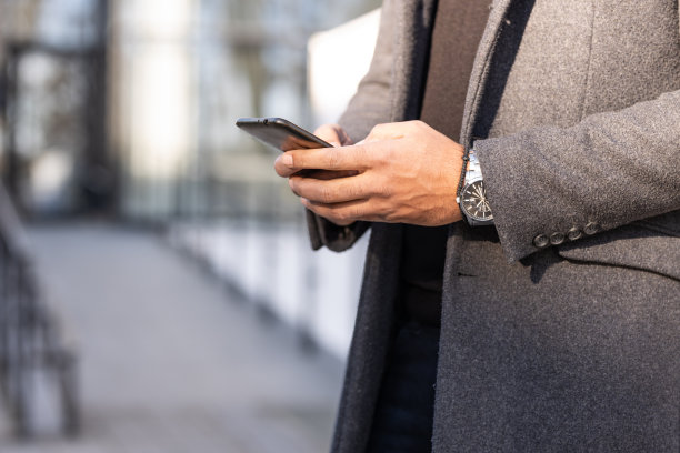 自信的商人拿着手机图片下载