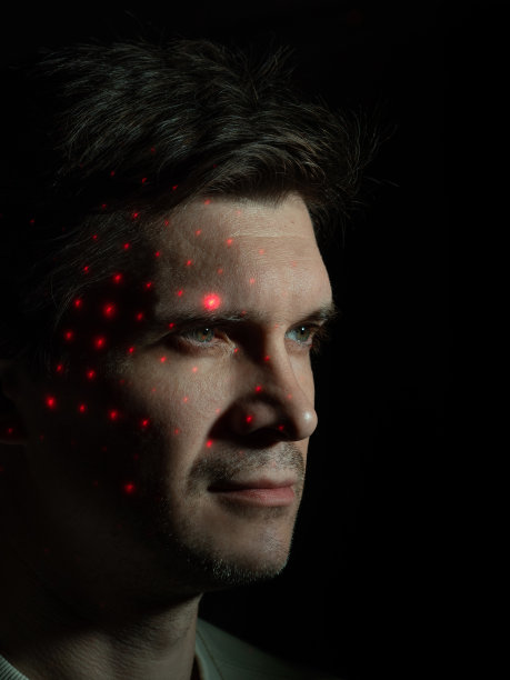 一个有思想的年轻人看着他脸上合适的虚拟界面，图片下载