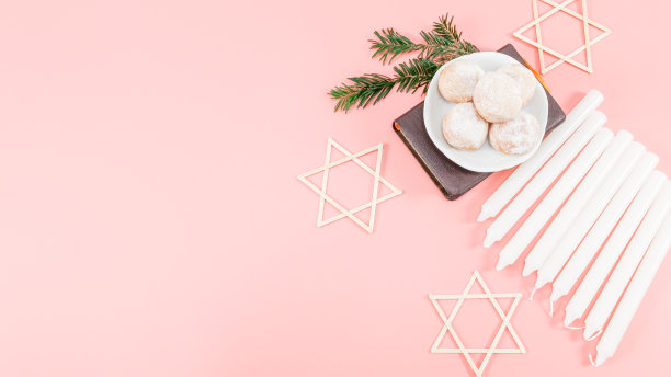 碟子里的甜甜圈粉，圣经，九根白色蜡烛和三颗木制的大卫星在右边图片下载