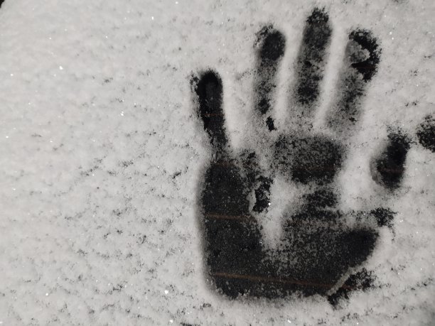 白雪覆盖的玻璃上有掌印。冬天的照片图片下载