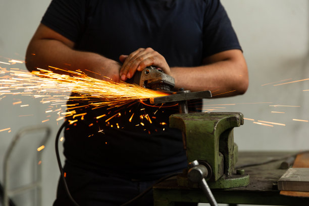 磨床工人使用磨床的工人，由于摩擦而产生火花图片下载