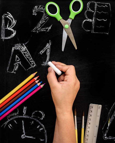 手用粉笔在学校的黑板上画数字和字母。图片下载