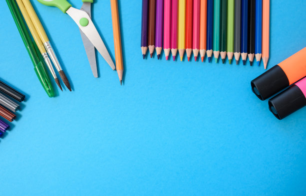 回到学校概念，马克笔，蜡笔，剪刀，钢笔，在蓝色背景上的画笔图片下载