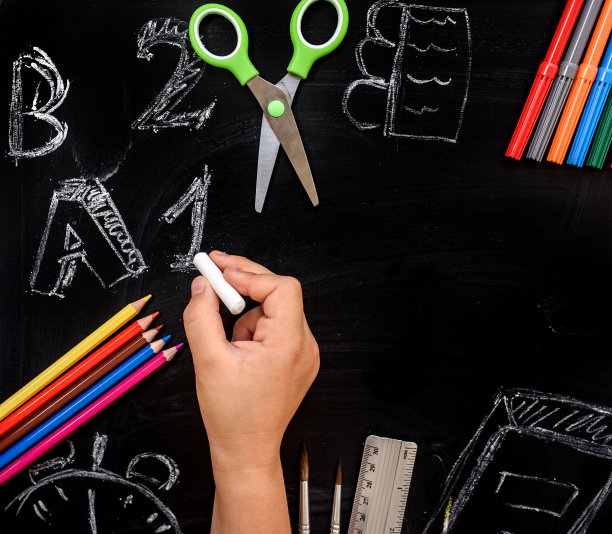 学生用粉笔在黑板上画数字和字母。图片下载