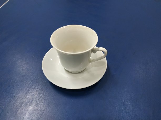 蓝色桌子上的白色陶瓷杯图片下载