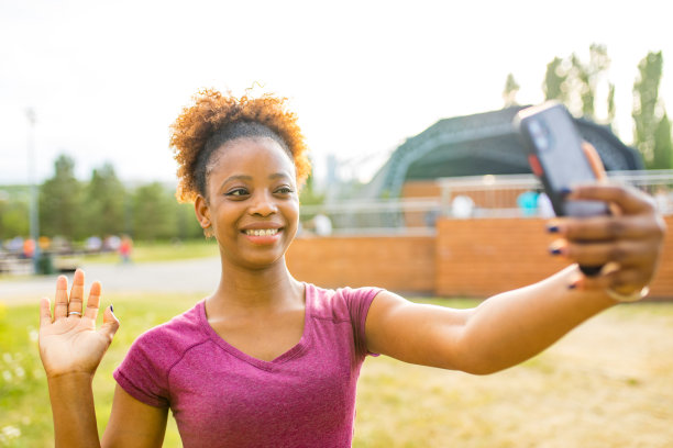 快乐的墨西哥女体育博主用三脚架上的相机记录户外健身训练图片下载