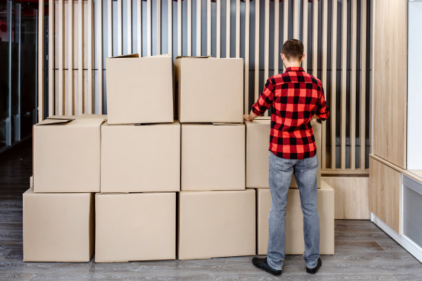 年轻的快递员正在安排纸箱包裹，等待发货图片下载