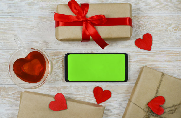 情人节背景和生态友好的礼物在牛皮纸与红丝带，木制心形装饰节日平躺，零浪费呈现俯视图与色度键屏幕图片下载