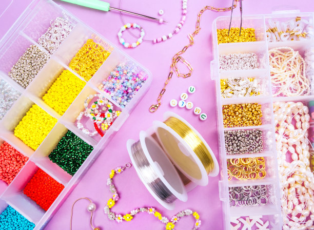 用制作珠宝的工具把种子珠子平铺在地上图片下载