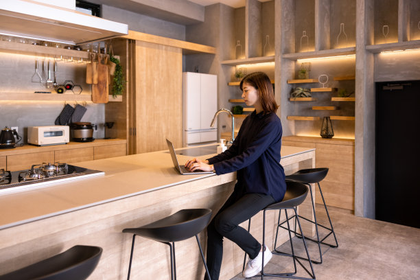 侧面的年轻女性餐厅员工使用笔记本电脑在厨房柜台图片下载