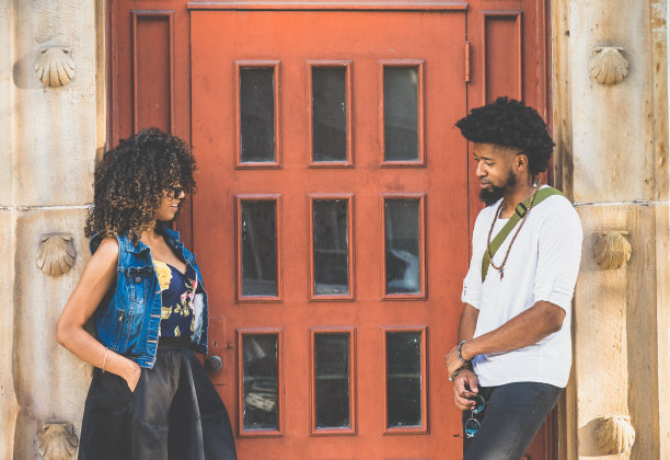 一对很酷的年轻黑人夫妇在砖红色的门前闲逛图片下载