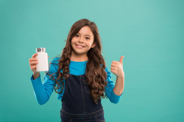 为了牙齿和骨骼。每日营养量。可爱的孩子要吃维生素了。食品添加剂。药片对孩子。维生素和矿物质的复合物。医学概念。提高免疫力。最好的维生素图片下载