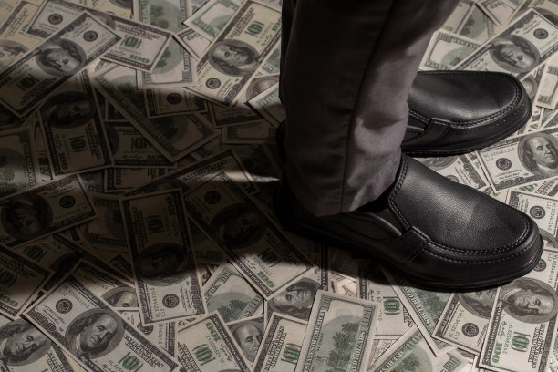 站在100美元钞票上的商人图片下载