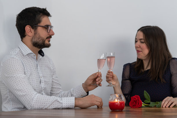 年轻夫妇在情人节喝香槟酒干杯图片下载