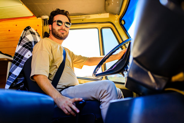 留着胡子的年轻卡车司机在卡车车棚里的肖像图片下载