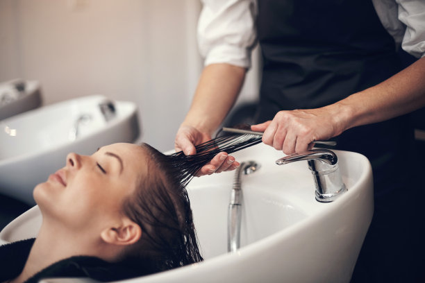 一个漂亮的年轻女人在美发沙龙洗头发的照片图片下载