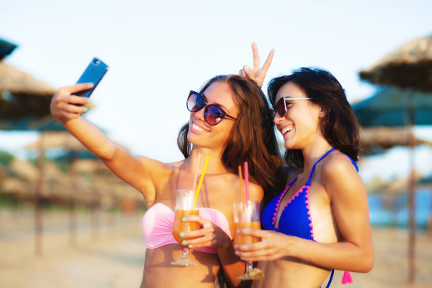 两个性感的女孩在海滩上自拍图片下载