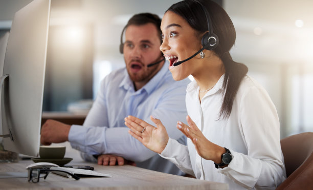 这张照片拍摄的是一位年轻的呼叫中心代理，晚上在办公室的电脑上工作时看起来很惊讶图片下载