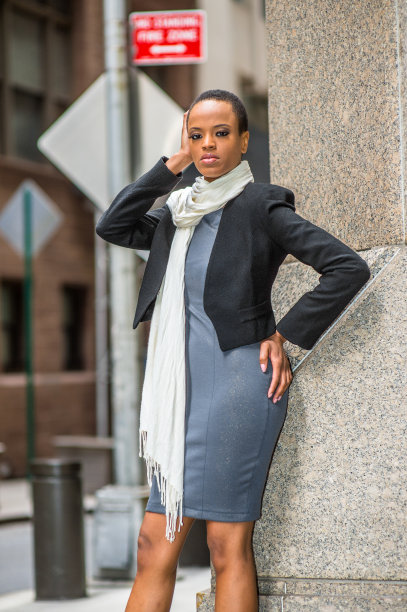 一个年轻的黑人女商人正站在办公室外面，放松着。图片下载