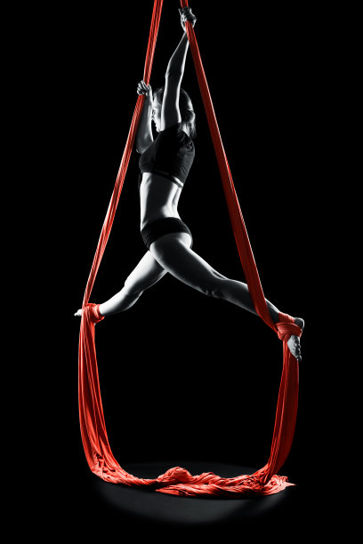 年轻女子体操运动员红色体操空中丝绸图片下载