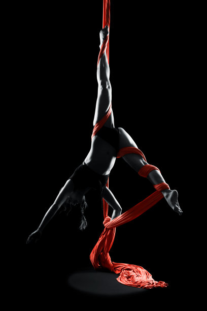 年轻女子体操运动员红色体操空中丝绸图片下载