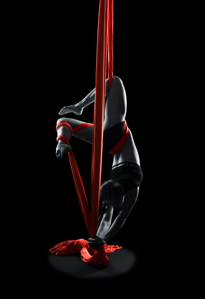 年轻女子体操运动员红色体操空中丝绸图片下载