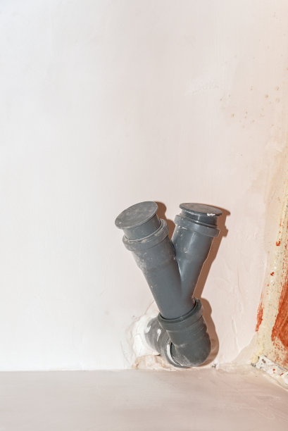 白色的墙上露出一条灰色的塑料下水管。图片下载