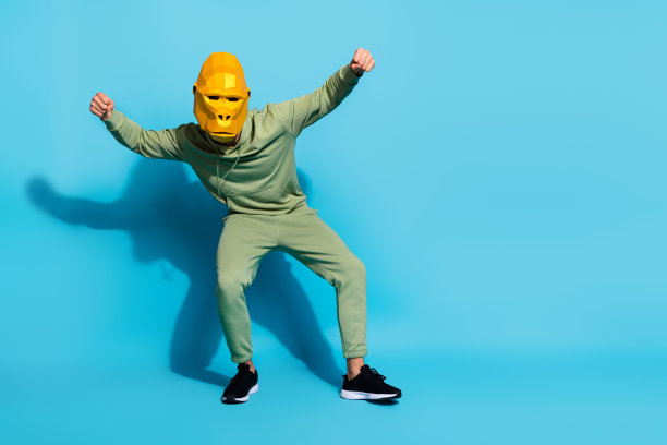 照片疯狂积极搞笑表演艺术家舞蹈猴动作戴大猩猩面具孤立蓝色背景图片下载