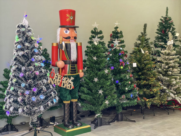 有趣的娃娃旁边的人造圣诞树在街上出售图片下载