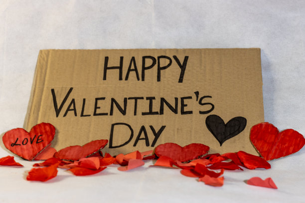 快乐情人节庆祝海报与心和红色花瓣在白色背景。情人节庆祝活动图片下载