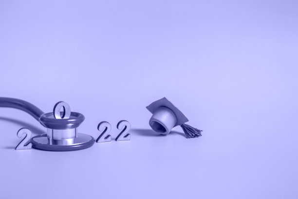 毕业帽与听诊器和数字2022蓝色背景，特写与复制空间。医学教育的概念。图片下载