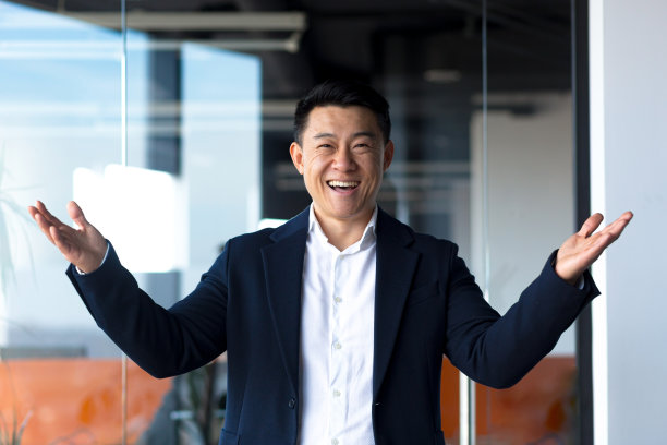 亚洲快乐的人看着镜头，竖起大拇指和ok的标志，商人微笑在现代的办公室图片下载