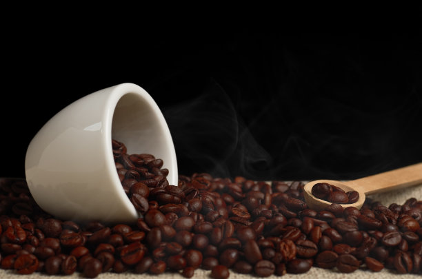在黑色背景的白色杯子里烘烤咖啡豆图片下载