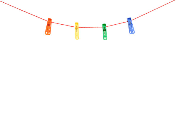 白色背景的晾衣绳上挂着五颜六色的晒衣夹。图片下载