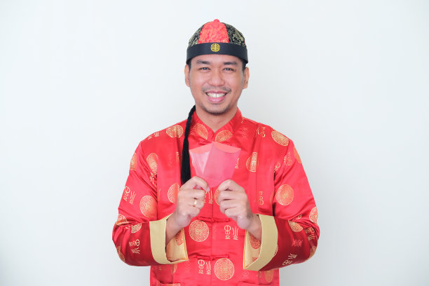 亚洲成年男子穿着中国服装“旗袍”微笑着拿着红包图片下载