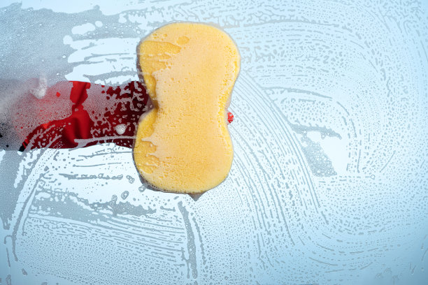 用泡沫海绵擦窗户时，可以看到后面的蓝天。图片下载