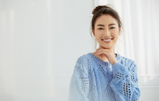 美丽的亚洲女人肖像放松脸在冬季卧室。特写性感美女时尚女孩健康化妆美容完美焕发肌肤。微笑快乐hygge亚洲韩国女孩穿蓝色毛衣图片下载